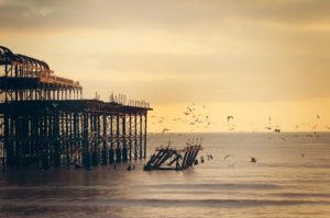 image of a pier with birds flying